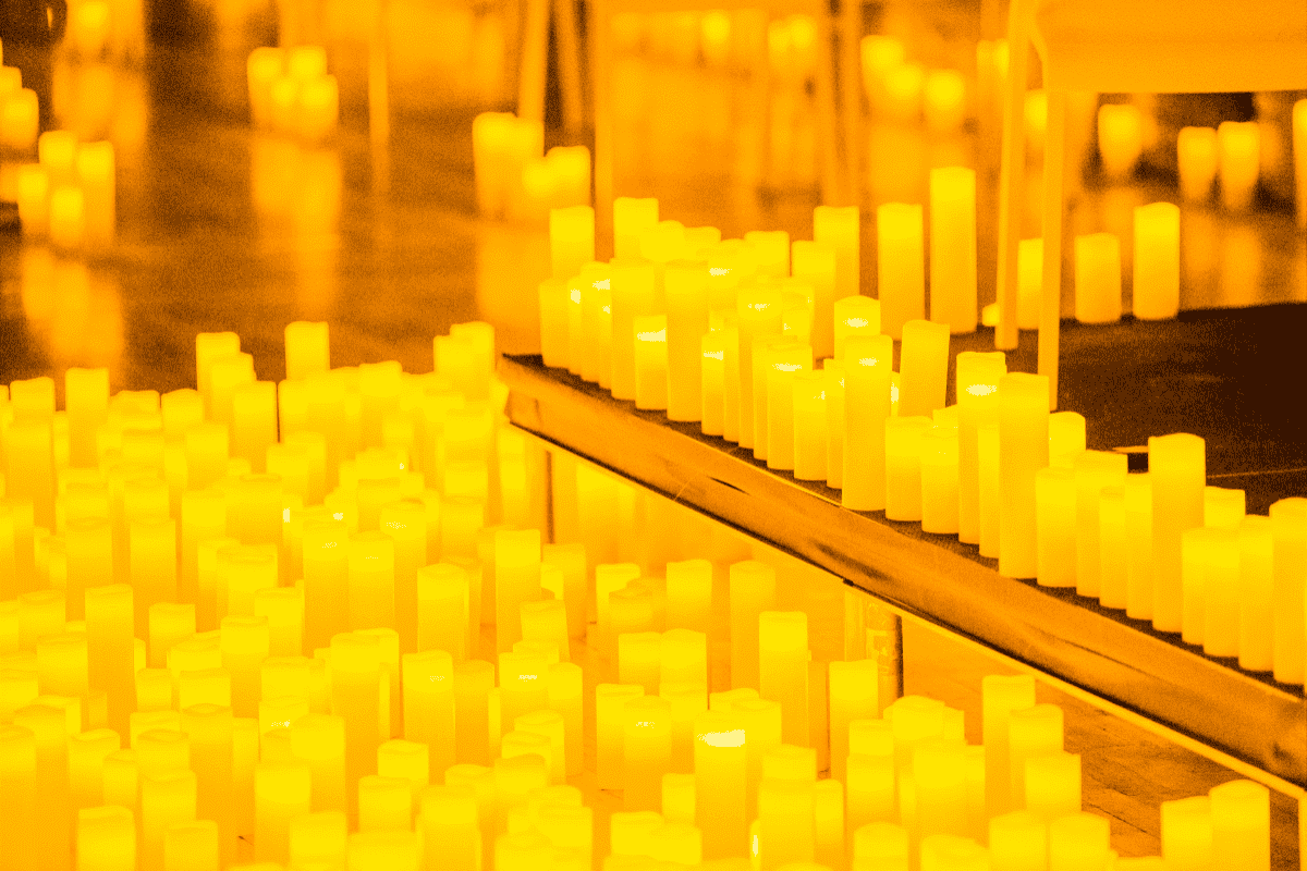 A sea of candles illuminates the space
