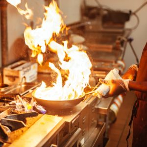 Chef cooking with flames in the wok, at Passage To India Indian Cuisine in Charlotte
